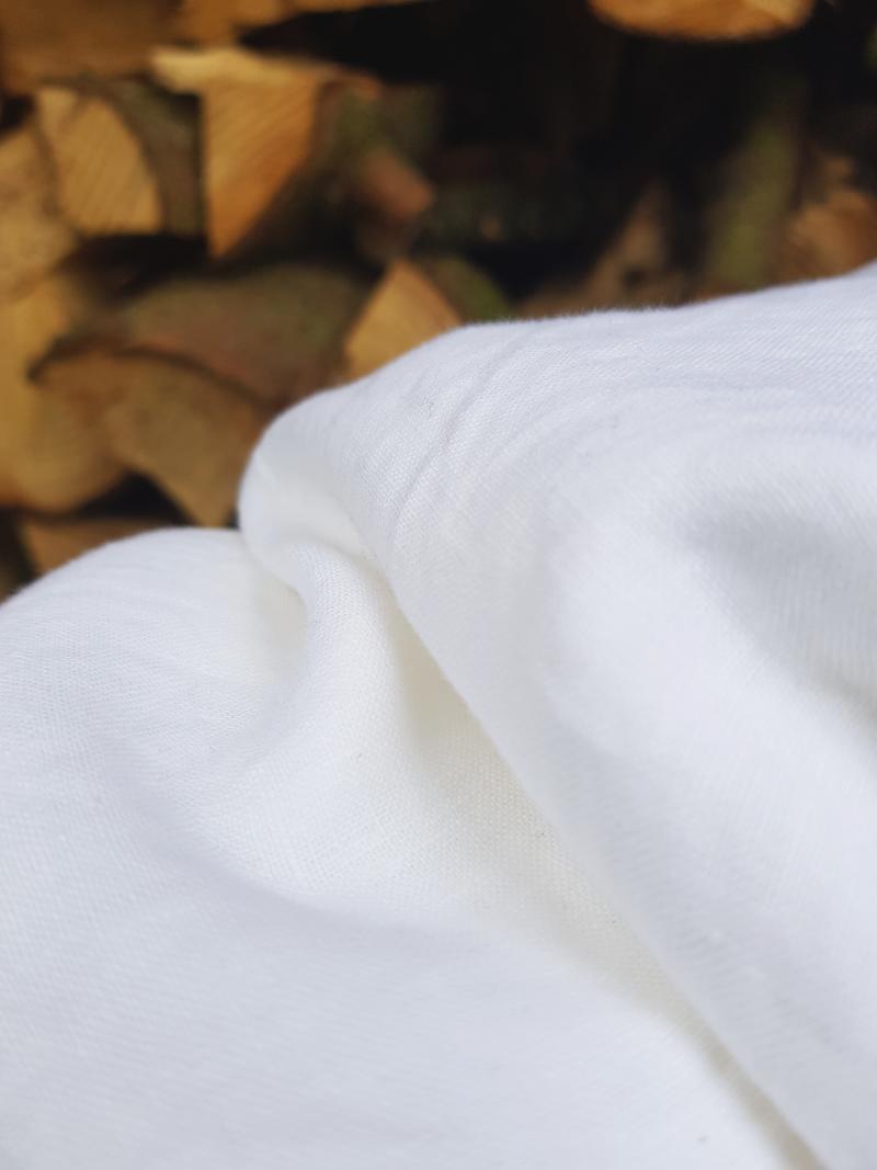 Weiße 200 x 200 cm Leinenbettwäsche vor dem Holzstapel